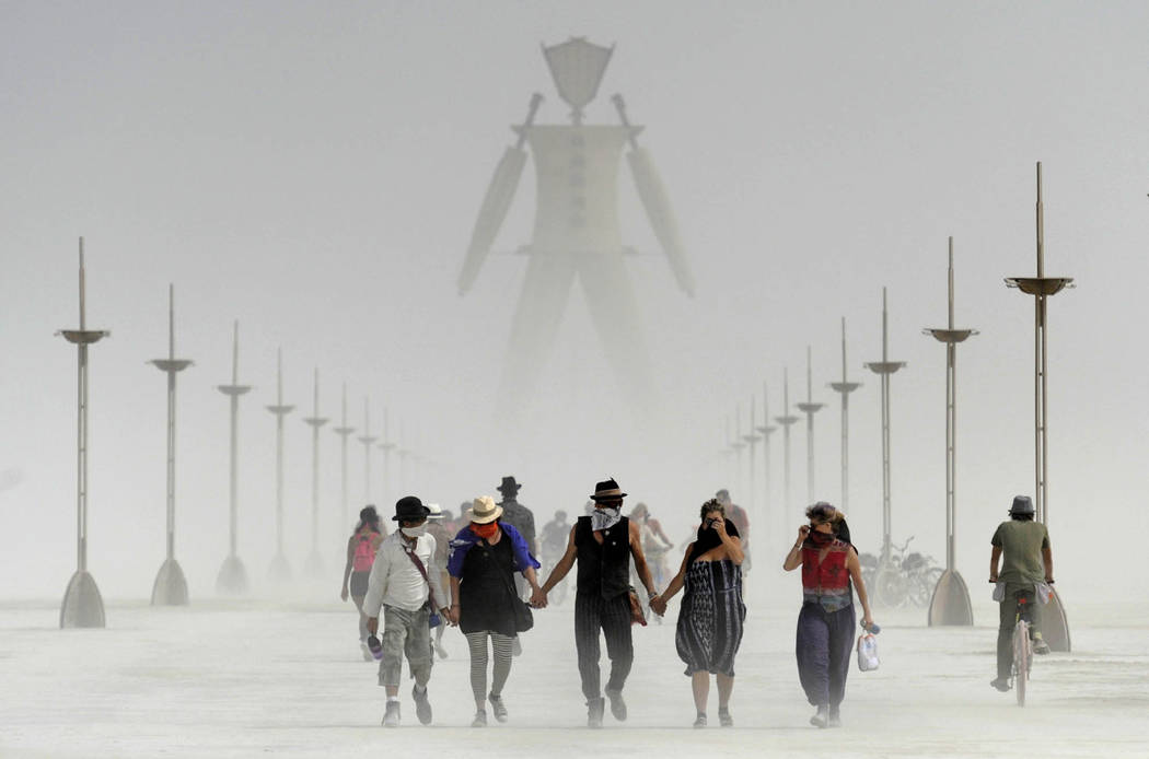In this Aug. 29, 2014 file photo, Burning Man participants walk through dust at the annual Burn ...