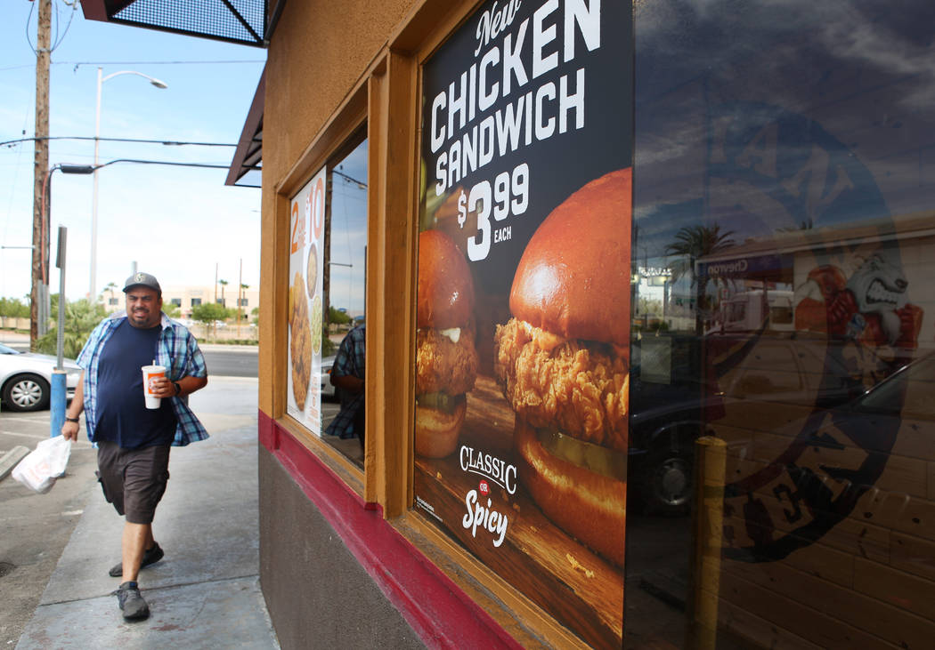 Dallas Scott walks back to his car after receiving his food at Popeyes on the corner of Bonanza ...