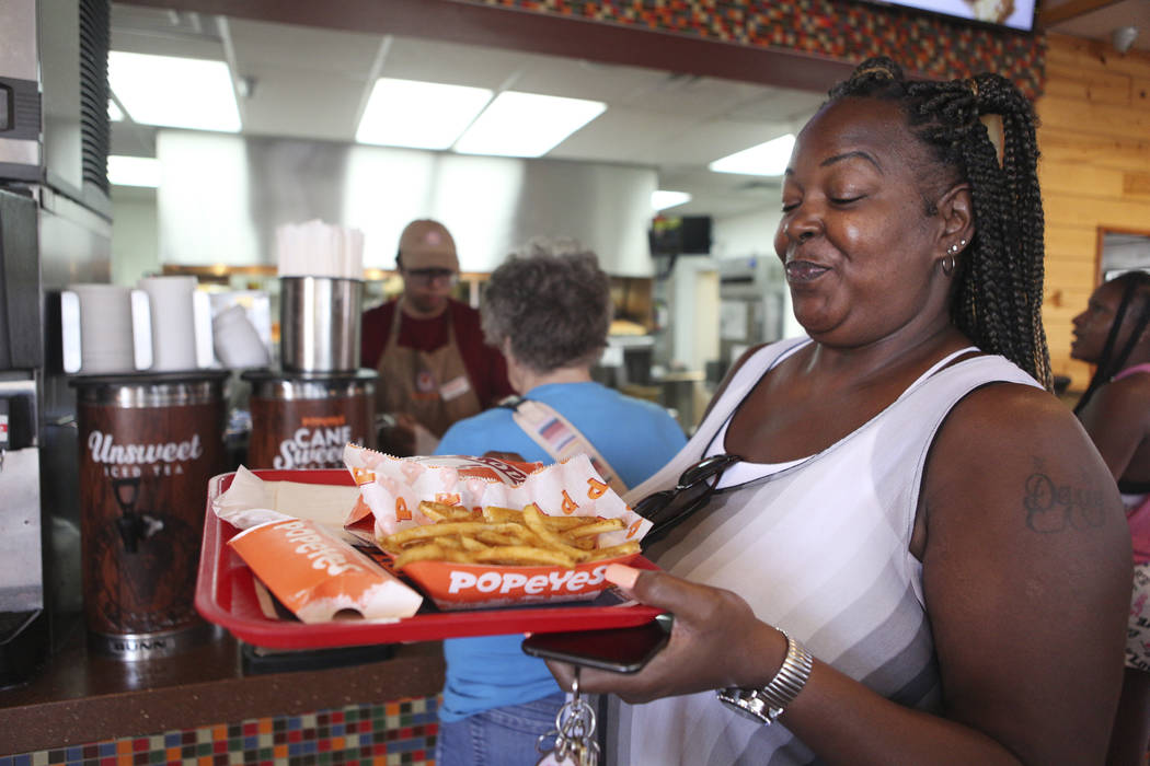 Janine Blake smiles after receiving her spicy chicken sandwich at Popeyes on the corner of Bona ...