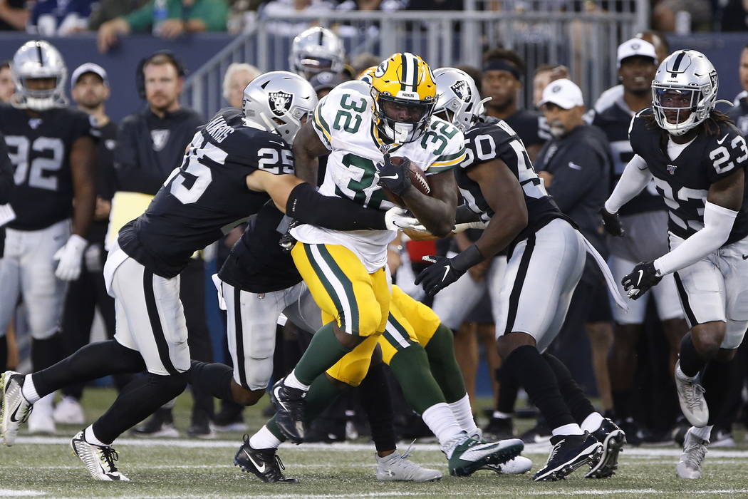 Green Bay Packers' Tra Carson (32) carries as Oakland Raiders' Erik Harris (25) attempts the ta ...