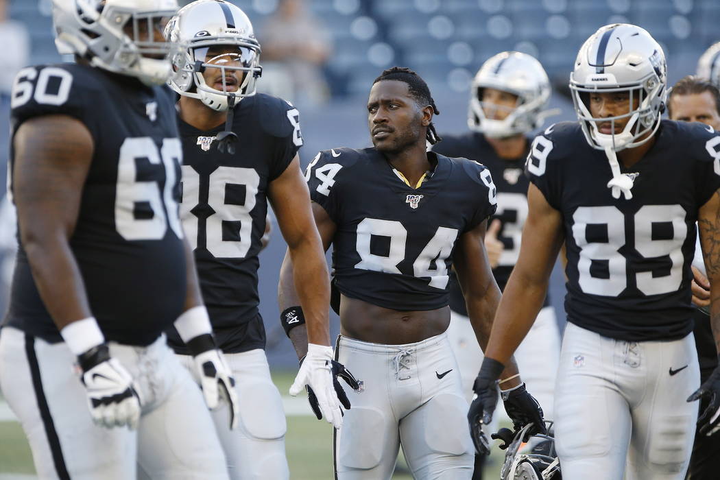 Oakland Raiders' Antonio Brown (84) and teammates gather before an NFL preseason football game ...