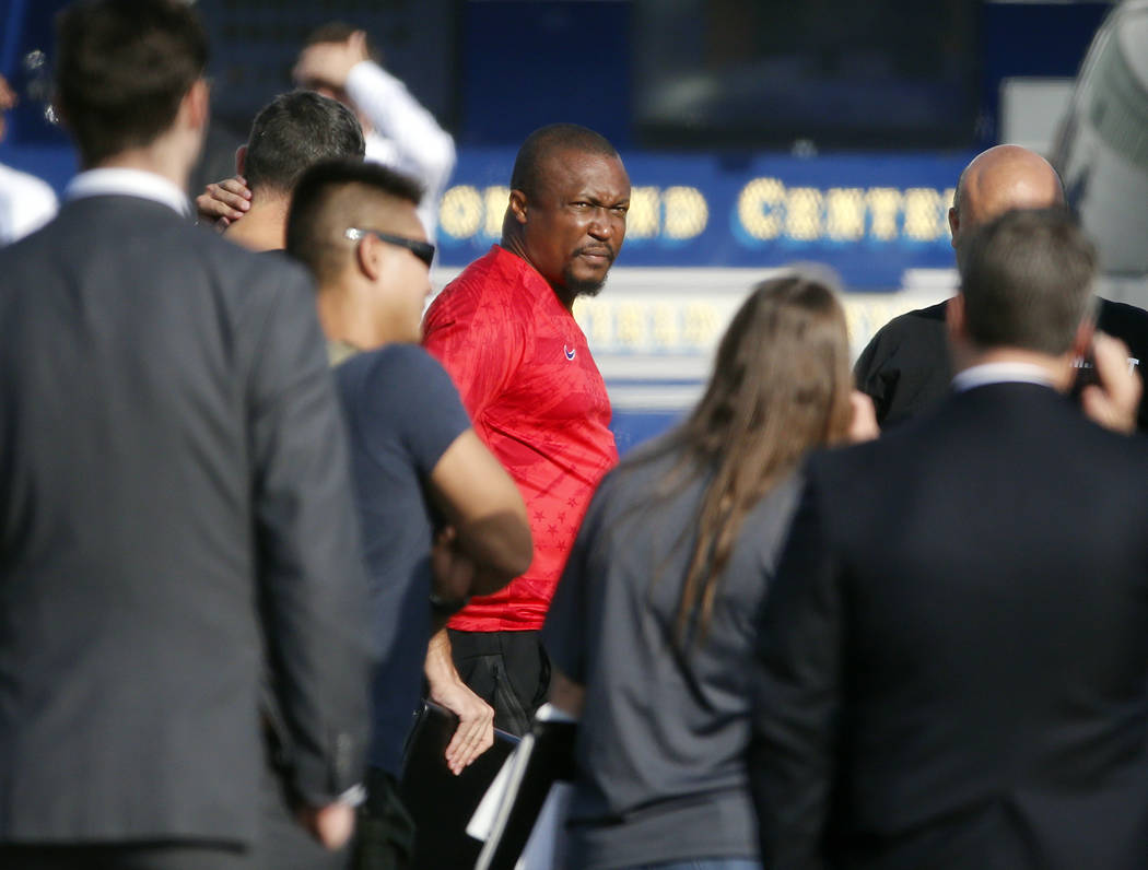 Federal agents hold a detainee, center, at a downtown Los Angeles parking lot after predawn rai ...