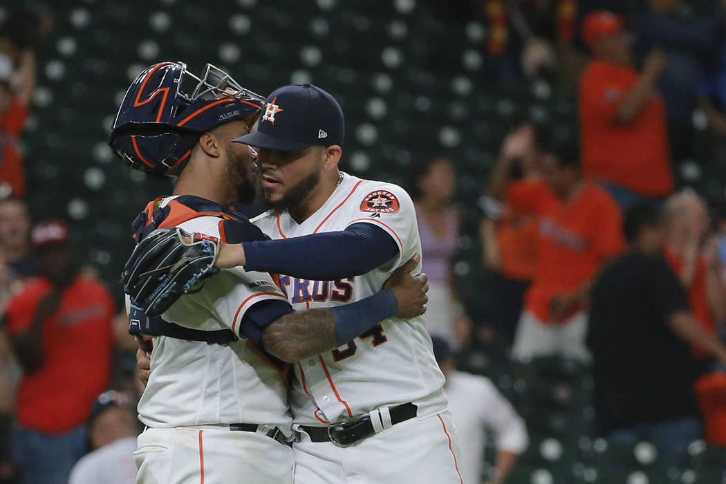 Houston Astros closer Roberto Osuna, right, celebrates with catcher Martin Maldonado as they de ...