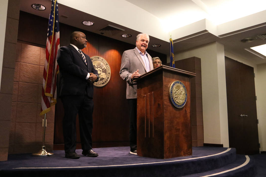 Gov. Steve Sisolak, center, speaks during a news conference at the Grant Sawyer State Office Bu ...