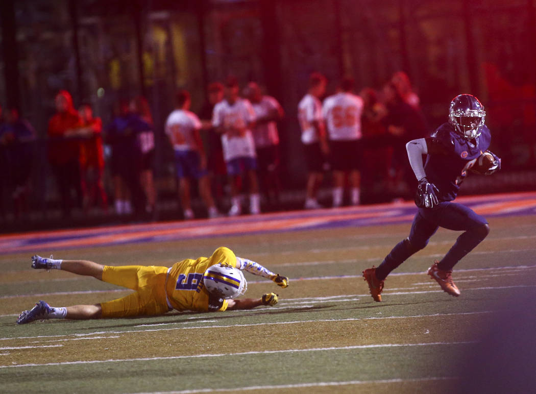 Bishop Gorman's Zachariah Branch (9) runs the ball past Orem's Joe Smith (9) during the first h ...