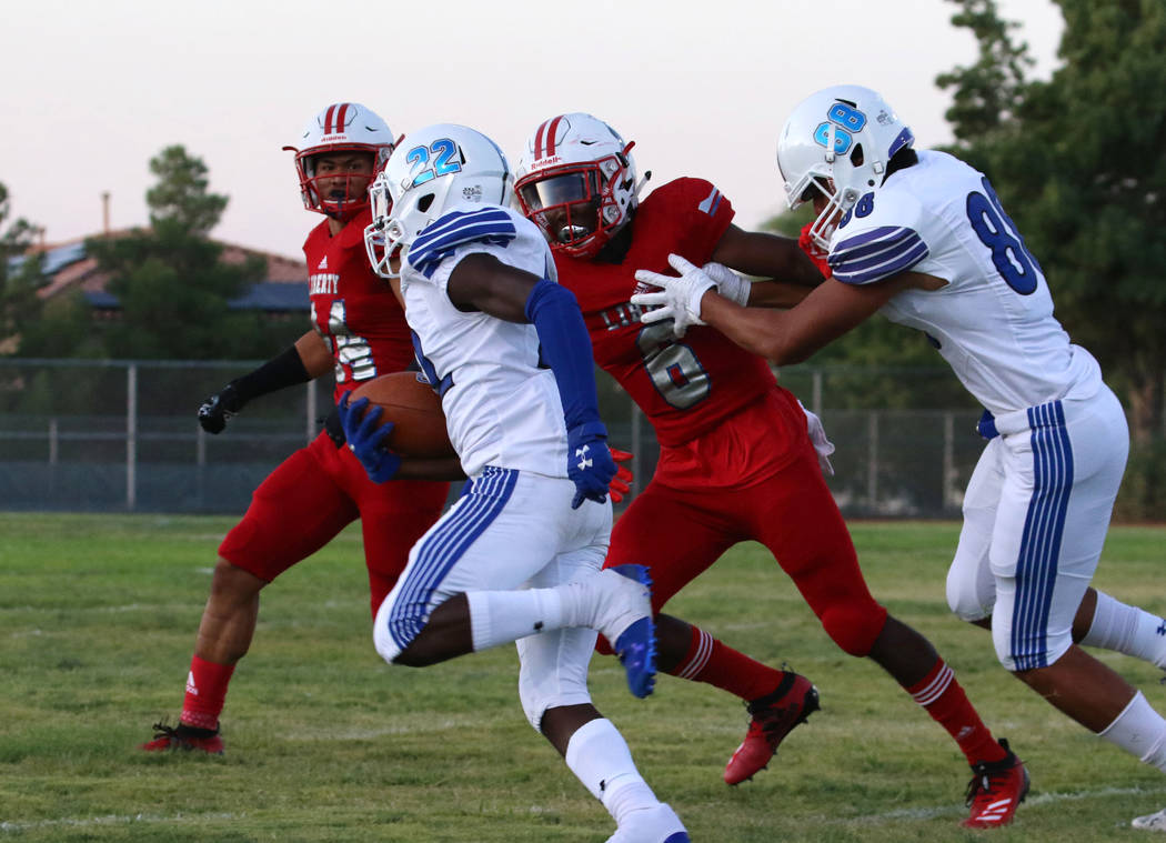 Chandler, Ariz., High's Quaron Adams (22) runs past Liberty High's Donte Bowers Jr. (6) during ...