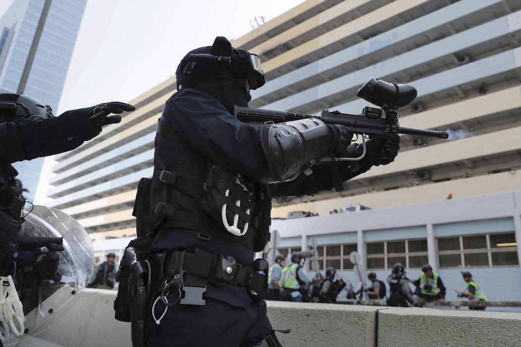 A police officer fires pepper balls during a demonstration in Hong Kong, Saturday, Aug. 24, 201 ...