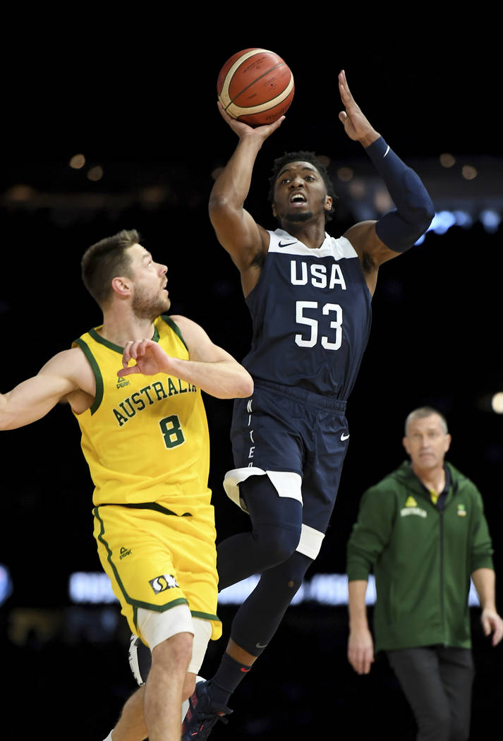 United States' Donovan Mitchell, right, attempts a basket against Australia's Matthew Dellavedo ...