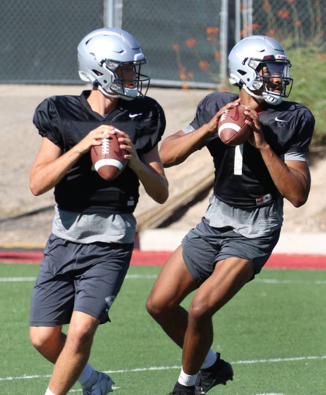 UNLV Rebels quarterbacks Kenyon Oblad, left, (7) and Armani Rogers (1) prepare to throw balls d ...