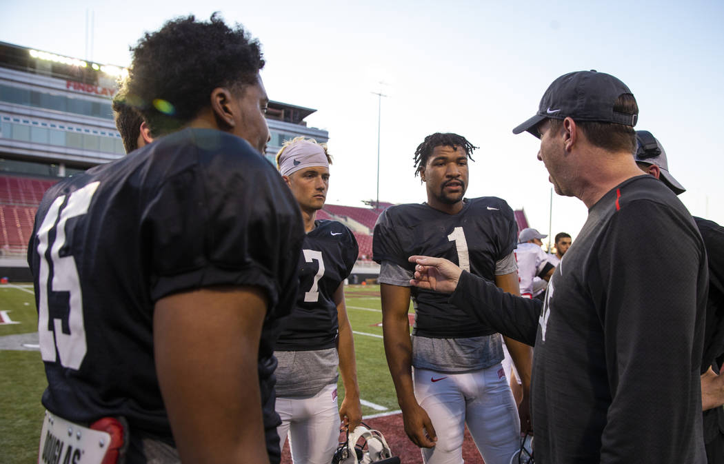 UNLV QB Armani Rogers (1, center) listens with others to quarterback's coach Ron O'Dell, right, ...