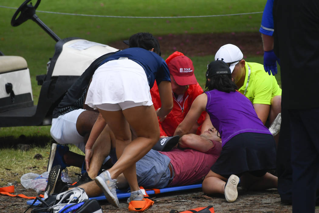 A spectators is tended to after a lightning strike on the course which left several injured dur ...