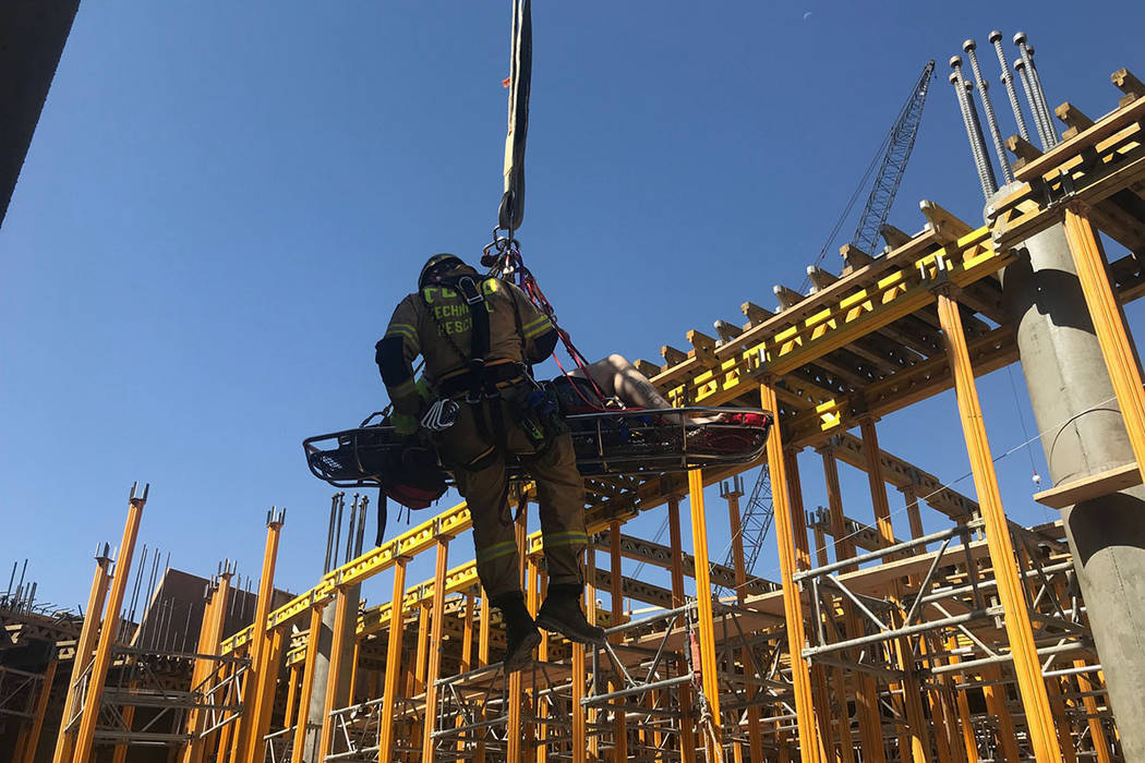 A member of the Clark County Fire Department helps with a rescue of a construction worker Satur ...