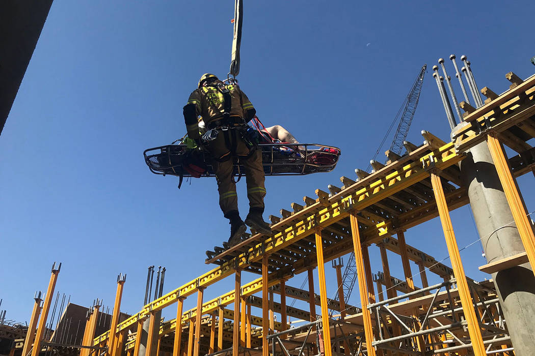 A member of the Clark County Fire Department helps with a rescue of a construction worker Satur ...