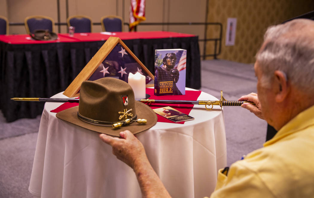 Pastor Bill Karabinos arranges a display as veterans and spouses who served in Vietnam particip ...