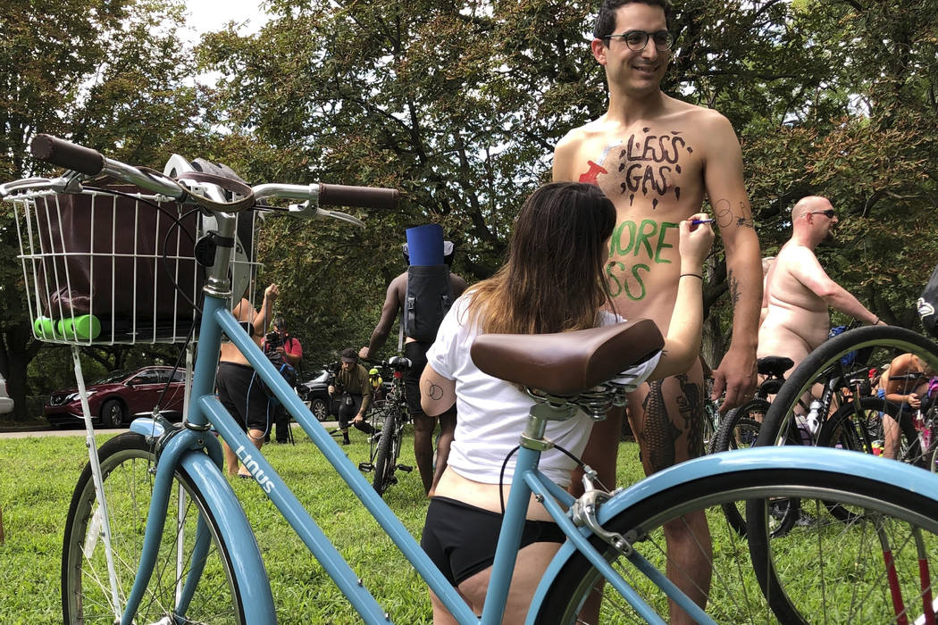 Nude bicyclist Oren Roth-Eisenberg has a message opposing fossil fuel consumption painted on hi ...