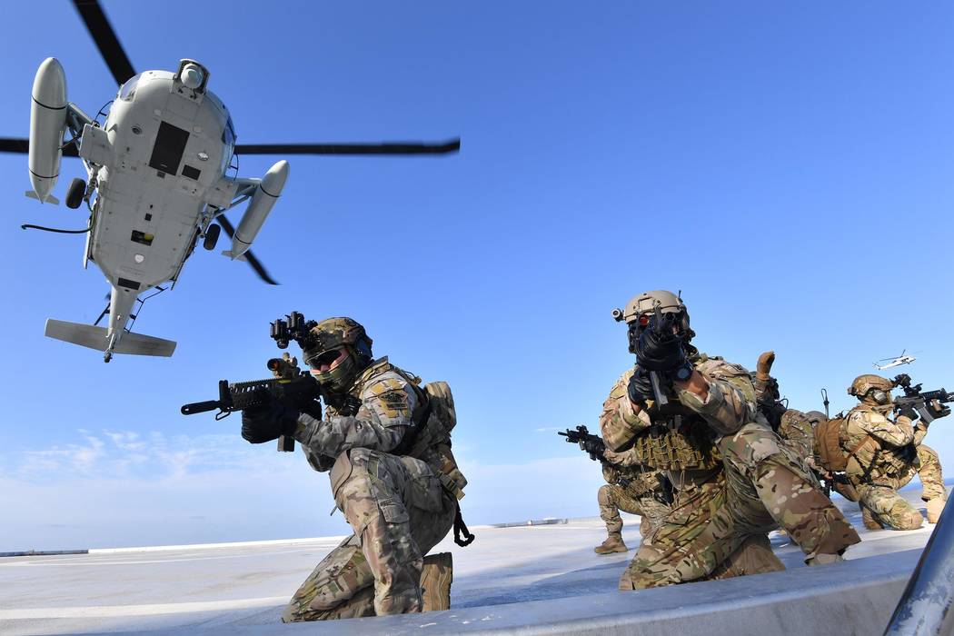 In this photo provided by South Korea's Navy, Members of South Korean Navy's special forces aim ...