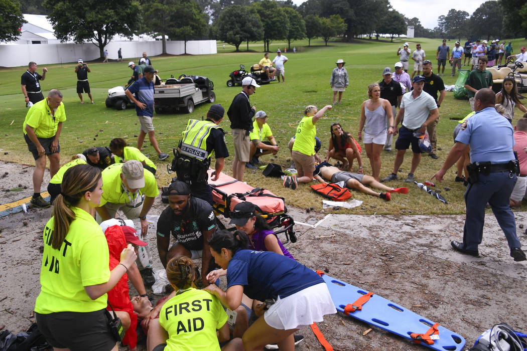 Spectators are tended to after a lightning strike on the East Lake Golf Club course left severa ...