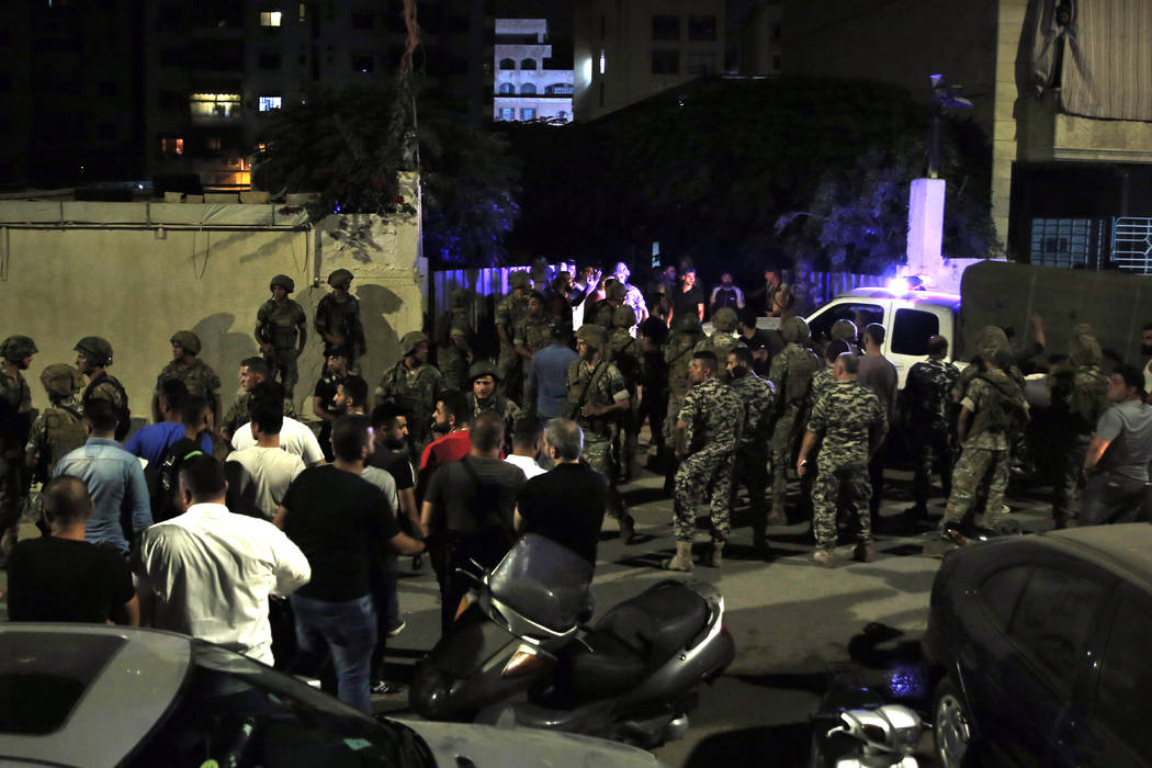 Lebanese security stand at the site where an Israeli drone was said to have crashed in a strong ...