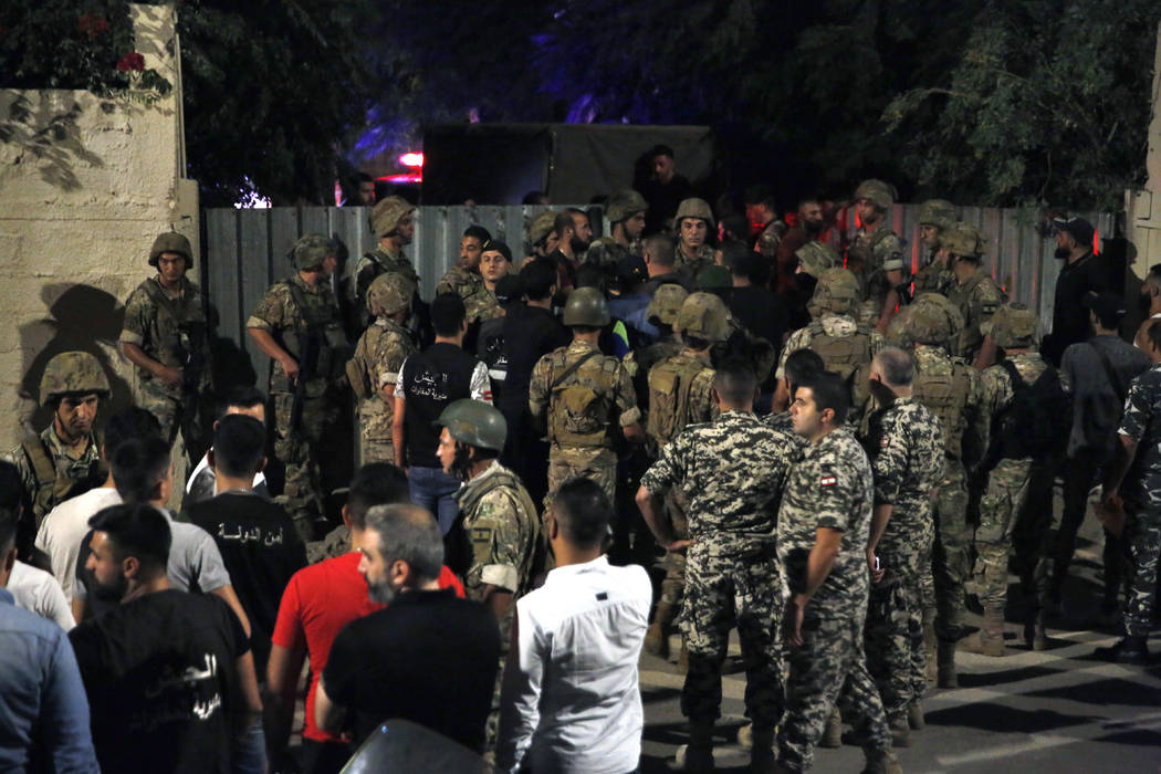 Lebanese security stand near the site where an Israeli drone was said to have crashed in a stro ...