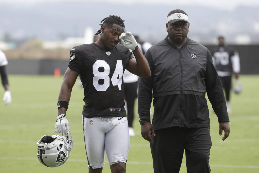 Oakland Raiders' Antonio Brown, left, walks off the field after NFL football practice in Alamed ...