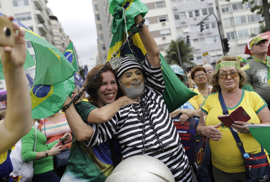 A man wearing a prison costume and mask of Brazil's former President Luiz Inacio Lula da Silva ...