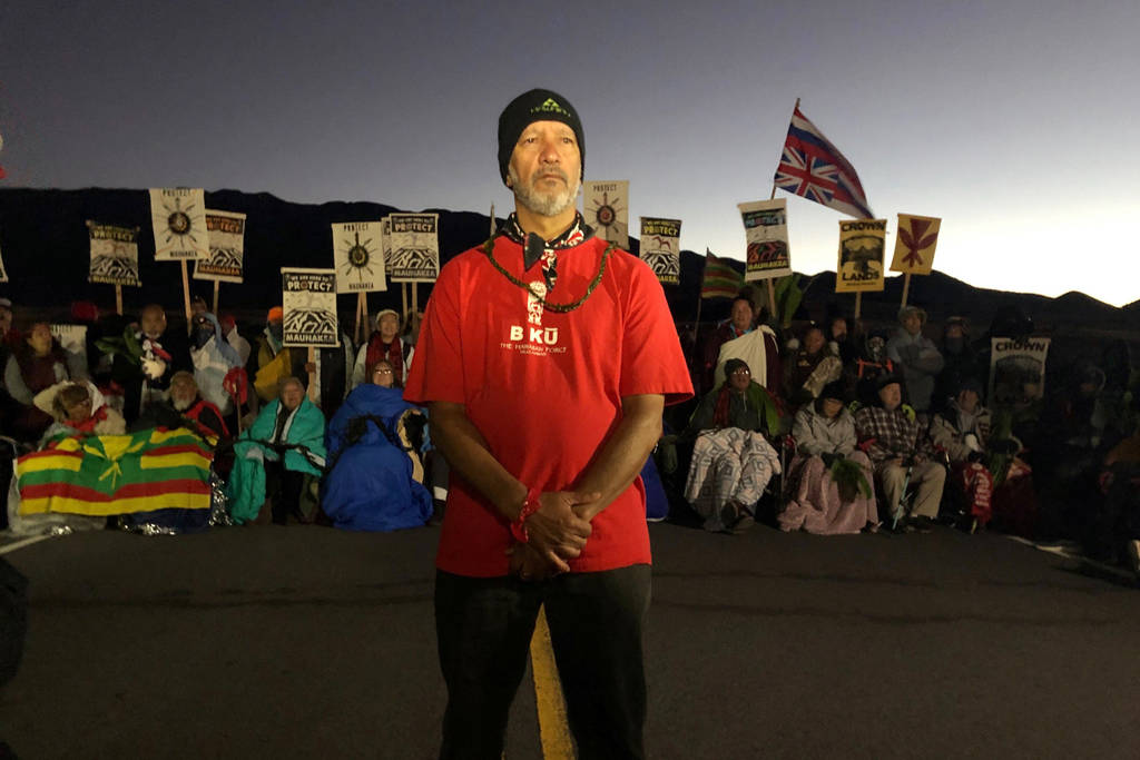 Dexter Kaiama, foreground, joins demonstrators gathered to block a road at the base of Mauna Ke ...