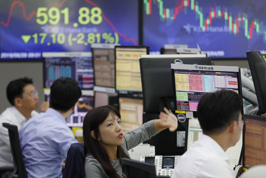 A currency trader gestures at the foreign exchange dealing room of the KEB Hana Bank headquarte ...