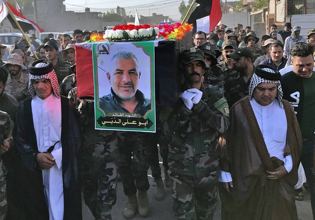 Mourners carry the coffin with a poster of Abu Ali al-Dabi, a fighter of the Popular Mobilizati ...