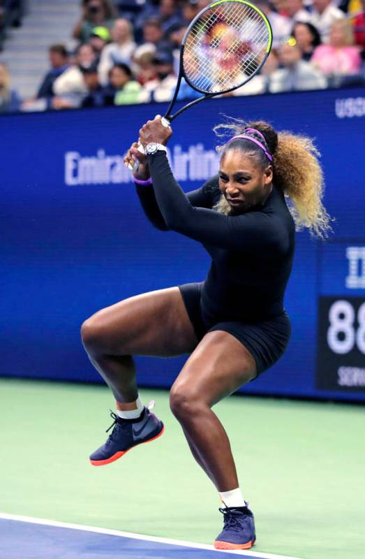 Serena Williams returns to Maria Sharapova during the first round of the U.S. Open tennis tourn ...