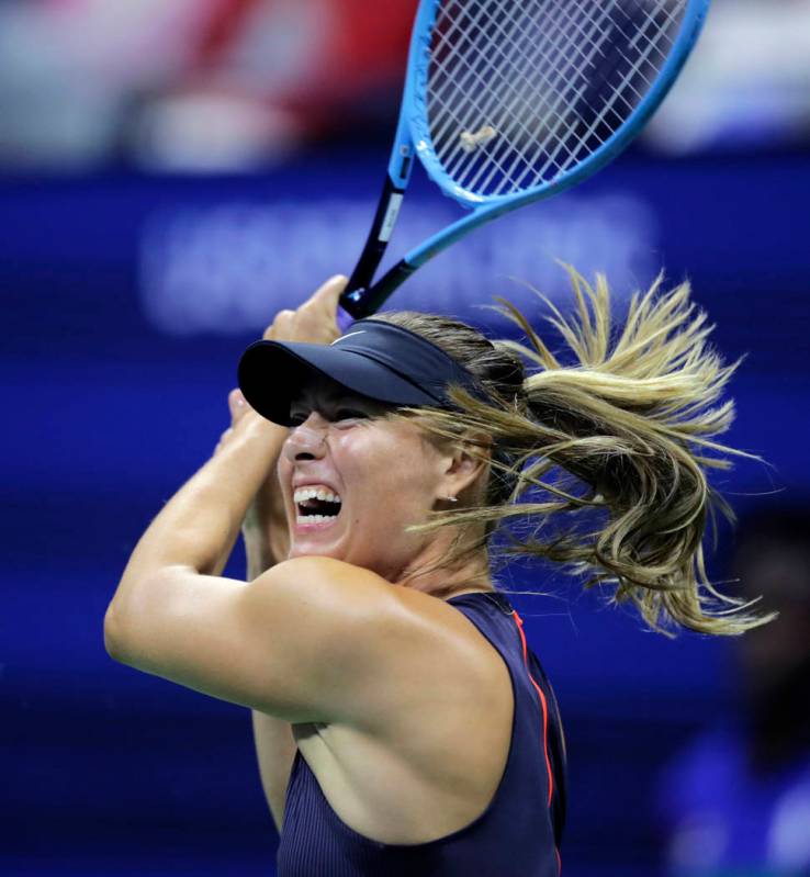 Maria Sharapova returns to Serena Williams during the first round of the U.S. Open tennis tourn ...