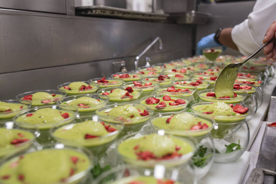 Chilled sweet pea, spinach and mint soup with basil-mint foam and strawberries are prepared for ...