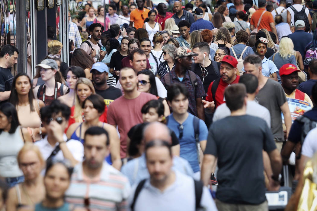 In this Aug. 22, 2019, photo, people walk through New York's Times Square. With just a few mont ...