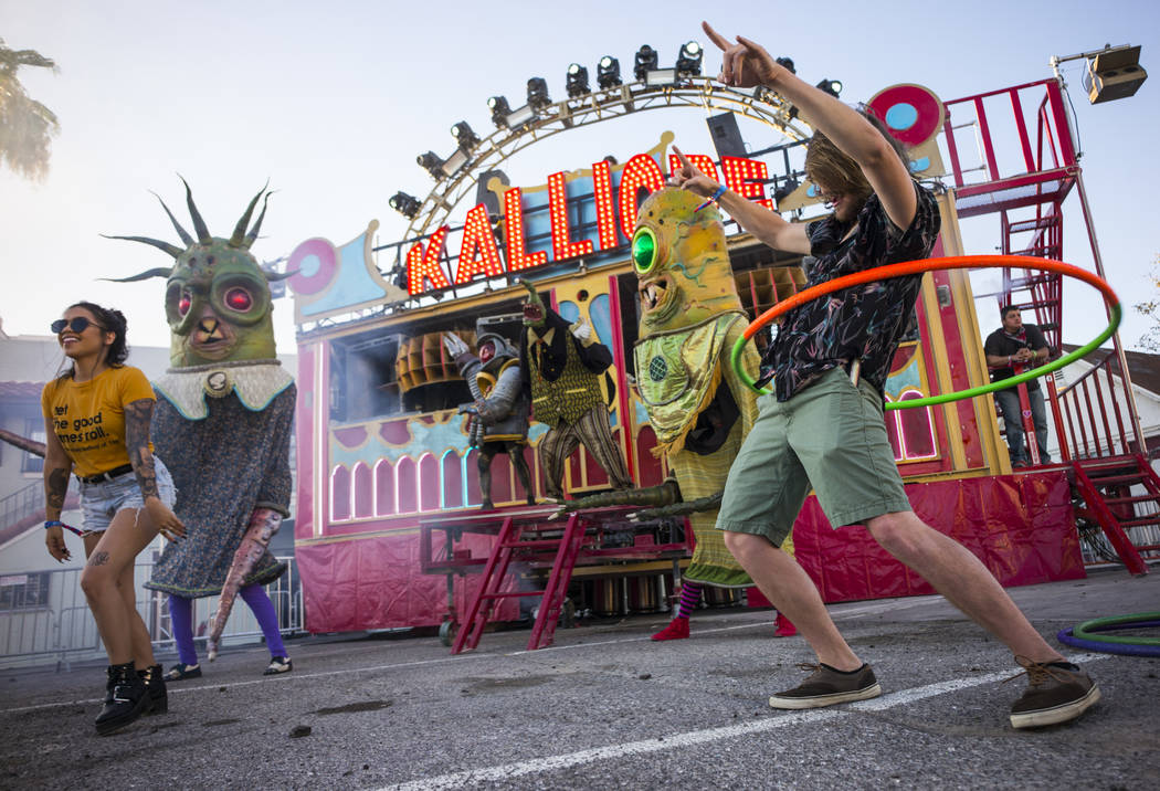 Creyton Bonestell of Palm Springs, Calif., right, hula hoops by the Kalliope art car during the ...