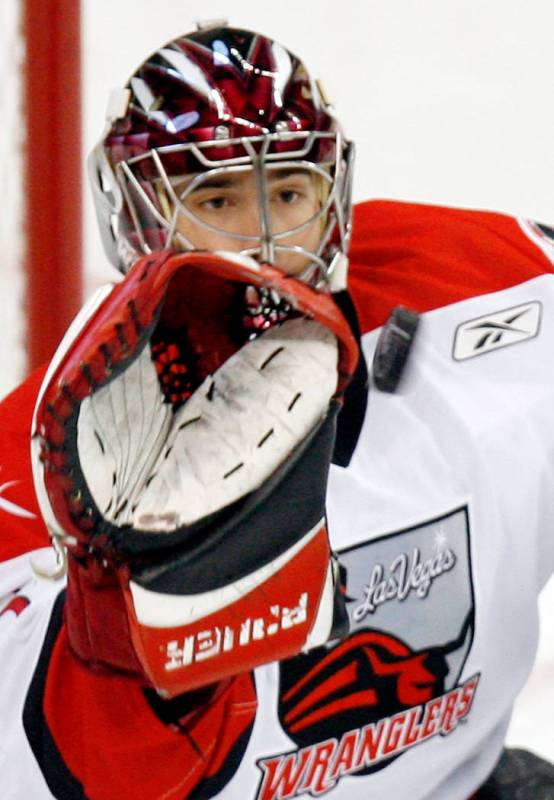 Las Vegas Wranglers goalie Mike McKenna stops a shot from a Victoria Salmon Kings player during ...