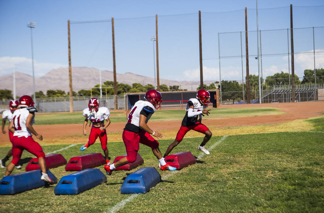 Players run through drills during football practice at the baseball field at Valley High School ...