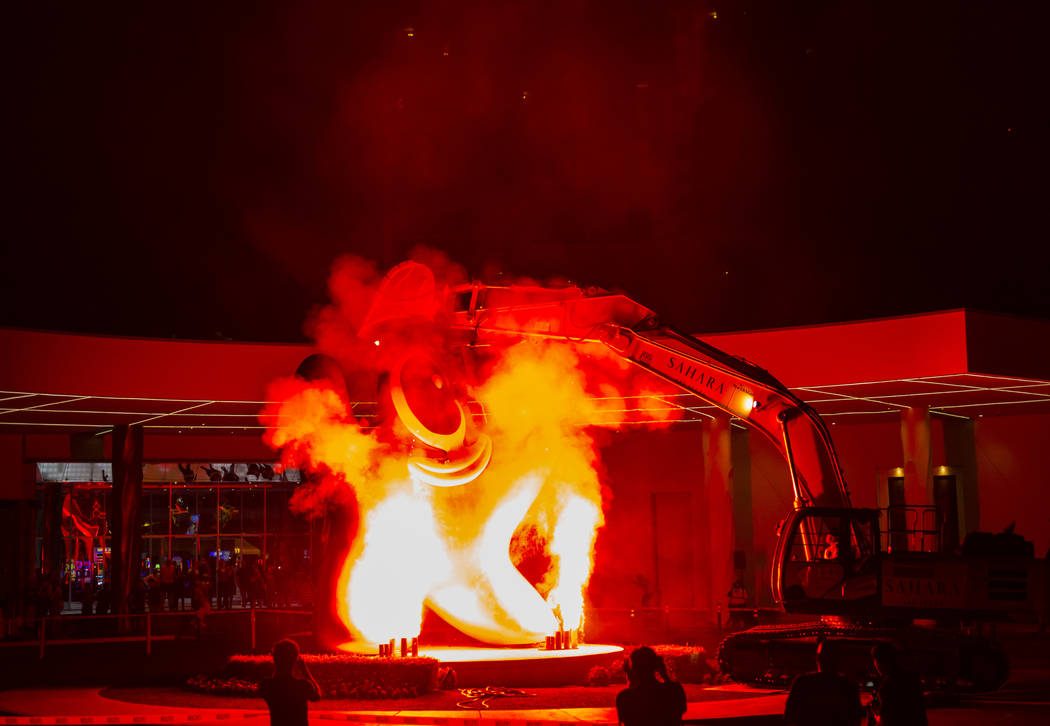 Flames shoot into the air prior to the removal of the "Sam by Starck" statue at the S ...