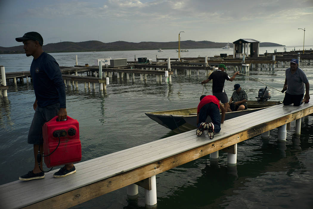 People arrive to a private harbor to move boats away for protection ahead of the arrival of Tro ...