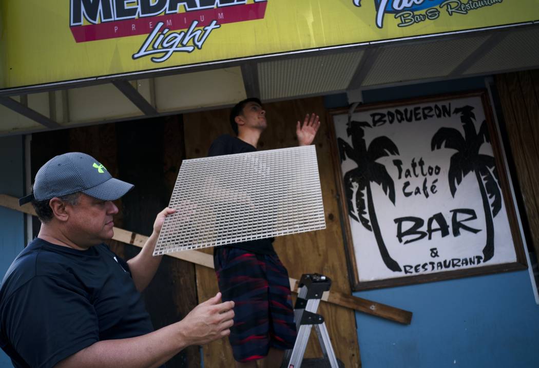 Men prep a local for the arrival of Hurricane Dorian in Boqueron, Puerto Rico, Tuesday, Aug. 27 ...