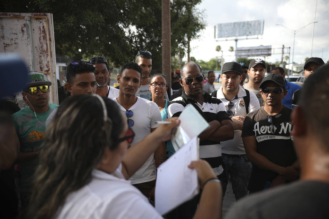 FILE - In this Aug. 2, 2019, file photo, migrants listen as a Mexican migration officer verifie ...