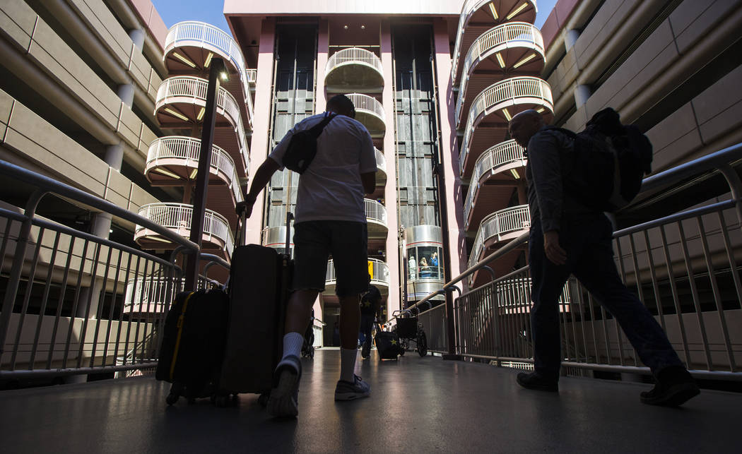 Passengers make their way to rideshare services and parking after arriving at McCarran Internat ...