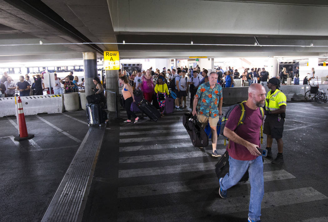 Passengers using rideshare services walk to their respective vehicles after arriving at McCarra ...