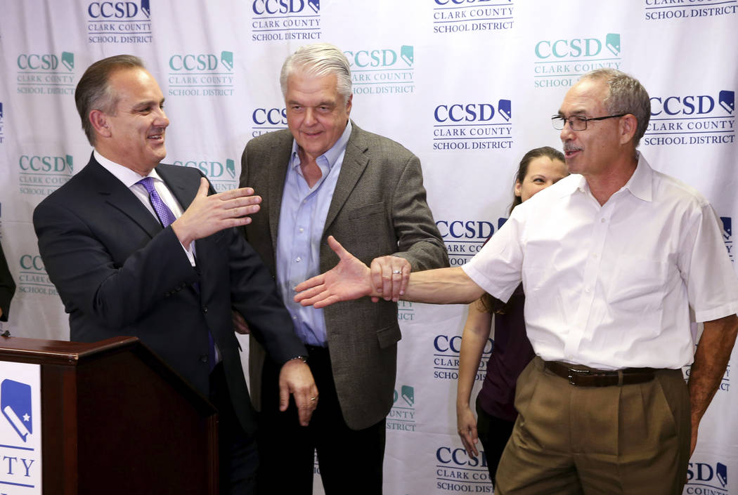 Gov. Steve Sisolak prods Clark County School District Superintendent Jesus Jara, left, and John ...