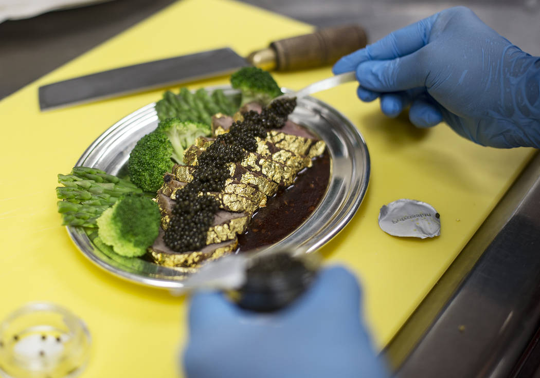 Executive Chef Zhen Han prepares The Gold Encrusted Filet Mignon by adding Petrossian Tsar Impe ...