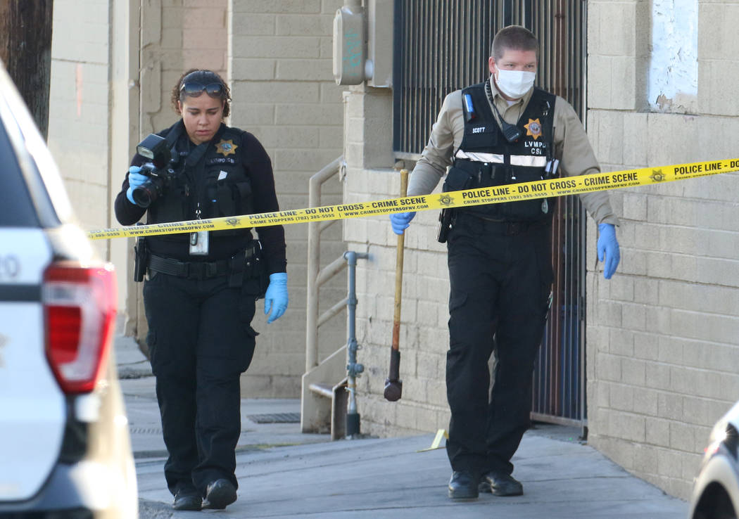 Las Vegas police collect evidence after a woman was killed with a sledgehammer on the 1000 bloc ...