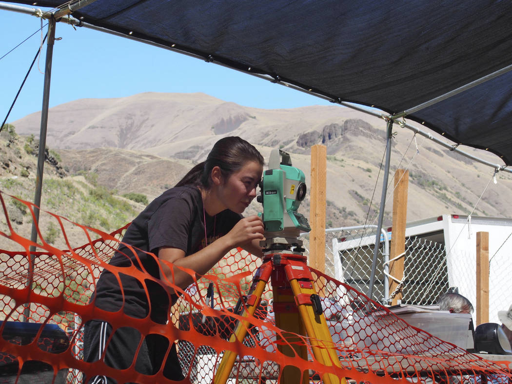 This 2015 photo provided by Loren Davis shows a researcher taking measurements at the Cooper's ...