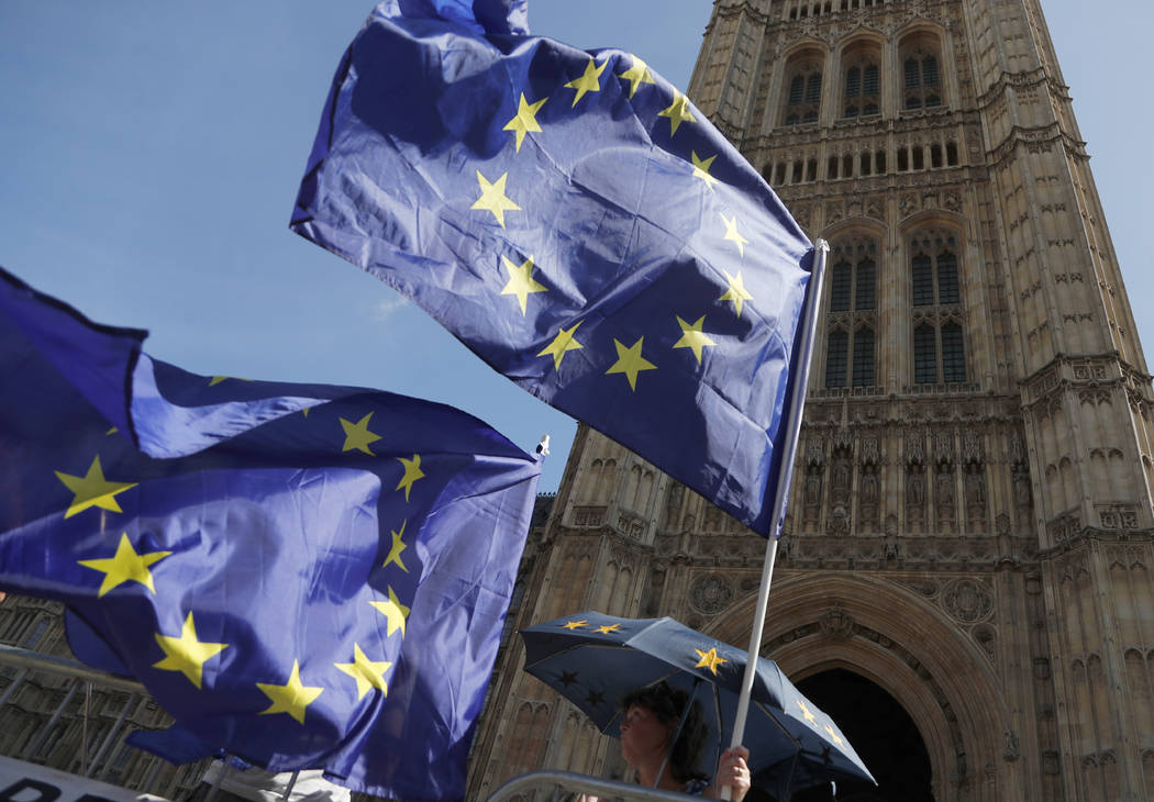 Anti Brexit protestors wave their flags opposite Parliament in London, Thursday, Aug. 29, 2019. ...