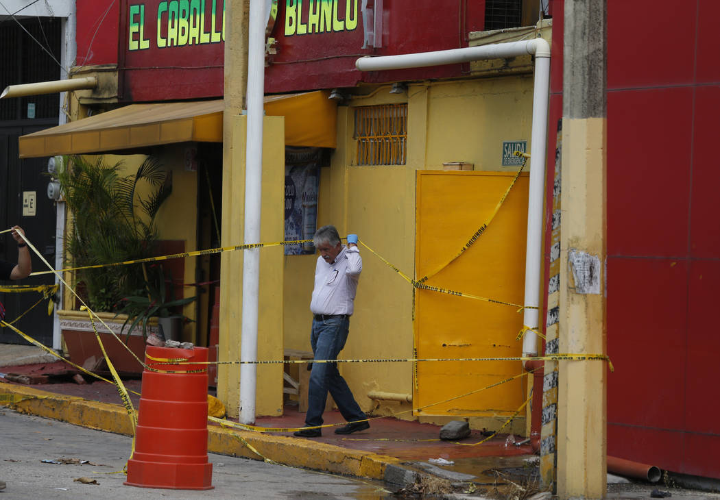 An investigator walks out of the White Horse nightclub (El Caballo Blanco in Spanish), the scen ...