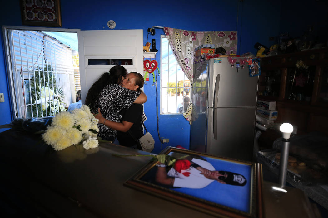 Vanessa Galindo Blas, 32, center right, gets a hug from a well-wisher during the wake for her l ...