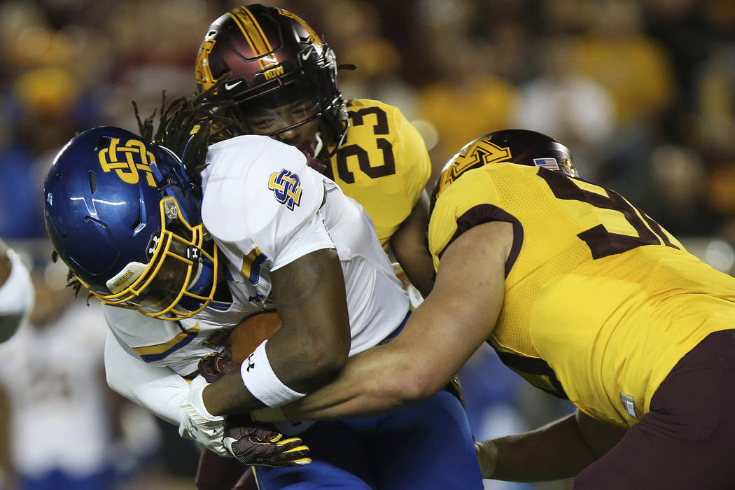 South Dakota State running back C.J. Wilson is tackled by Minnesota defensive back Jordan Howde ...