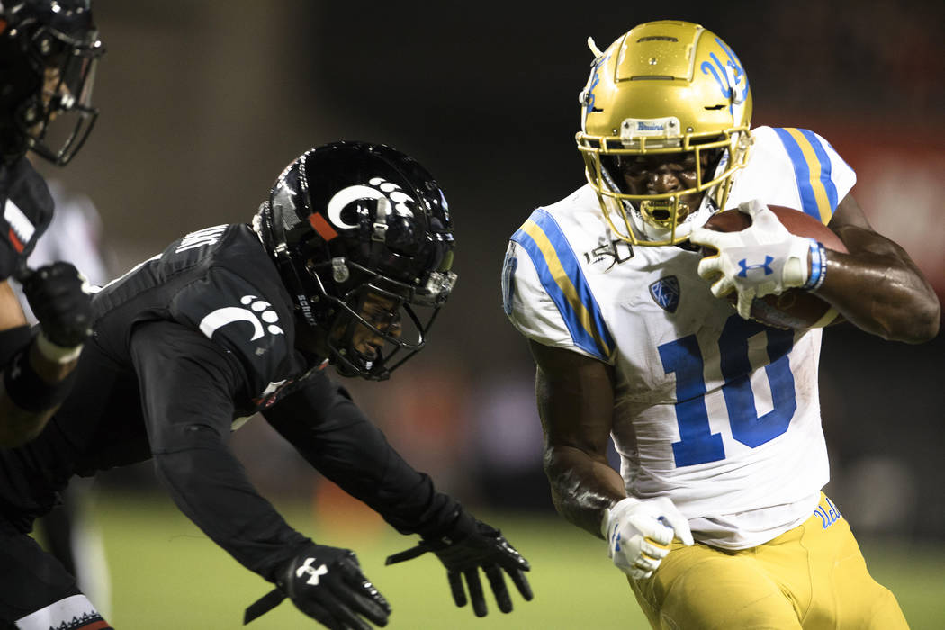 Cincinnati safety Darrick Forrest forces UCLA wide receiver Demetric Felton (10) out of bounds ...